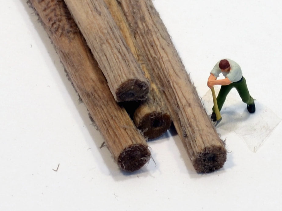 HO scale logs 5/16ths diameters made by Coastman's Scenic Products included in Variety Pak Logs showing scale by virtue of a HO scale figurine with a peavey tool attempting to roll the log. Photo by Roger Rasmussen.