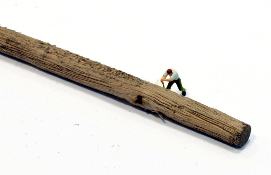 HO scale log made by Coastman's Scenic Products included in Variety Pak Logs showing scale by virtue of a HO scale figurine with a peavey tool attempting to roll the log. Photo by Roger Rasmussen.