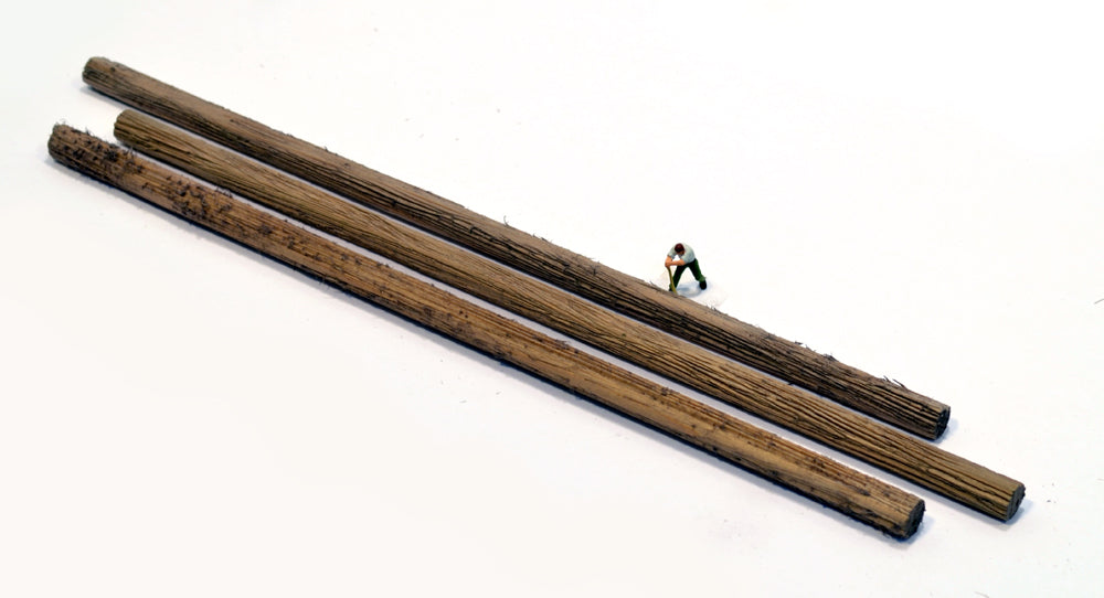 HO scale logs 3/8ths diameters made by Coastman's Scenic Products included in Variety Pak Logs showing scale by virtue of a HO scale figurine with a peavey tool attempting to roll the log. Photo by Roger Rasmussen.
