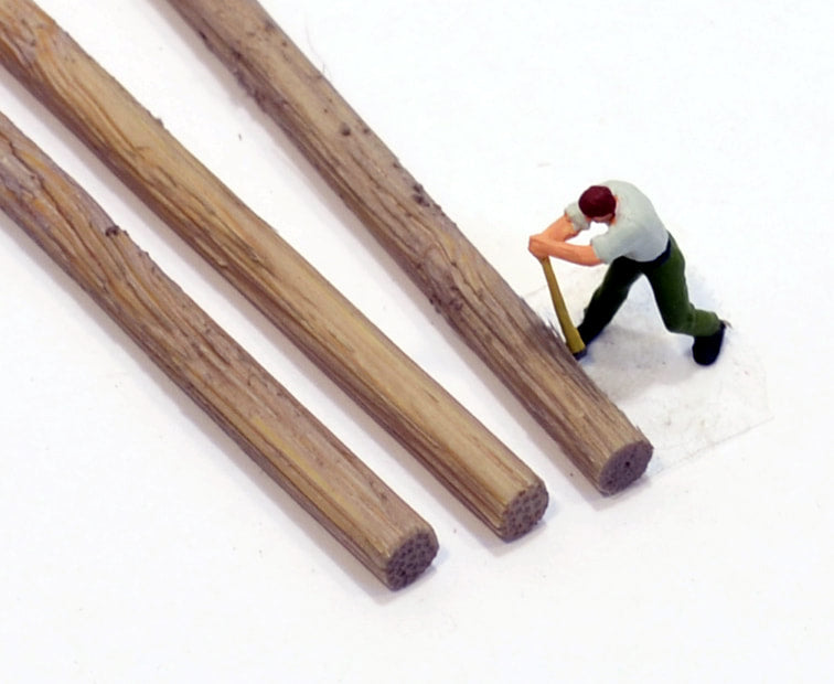 HO scale logs 5/16ths diameters made by Coastman's Scenic Products included in Variety Pak Logs showing scale by virtue of a HO scale figurine with a peavey tool attempting to roll the log. Photo by Roger Rasmussen.