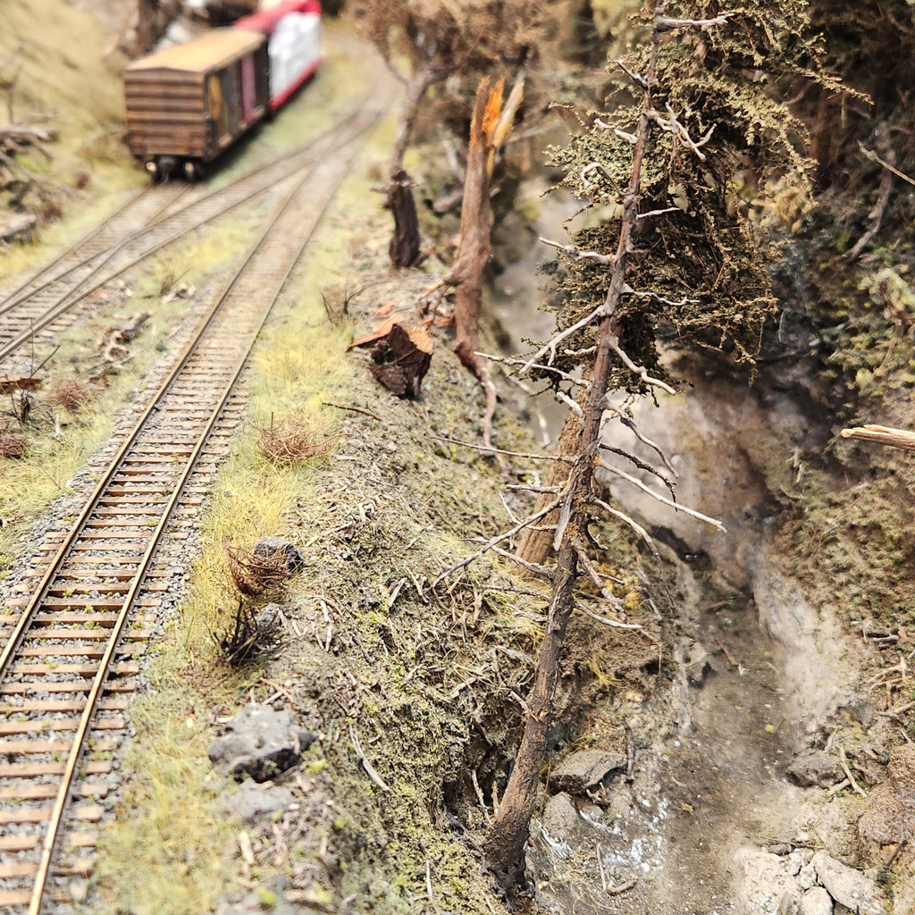 Coastman's Forest Floor scenic material as seen on Roger's Port of Tillamook Bay HO scale shortline model railroad along with other scenery items and HO scale railroad track and boxcar in the distance