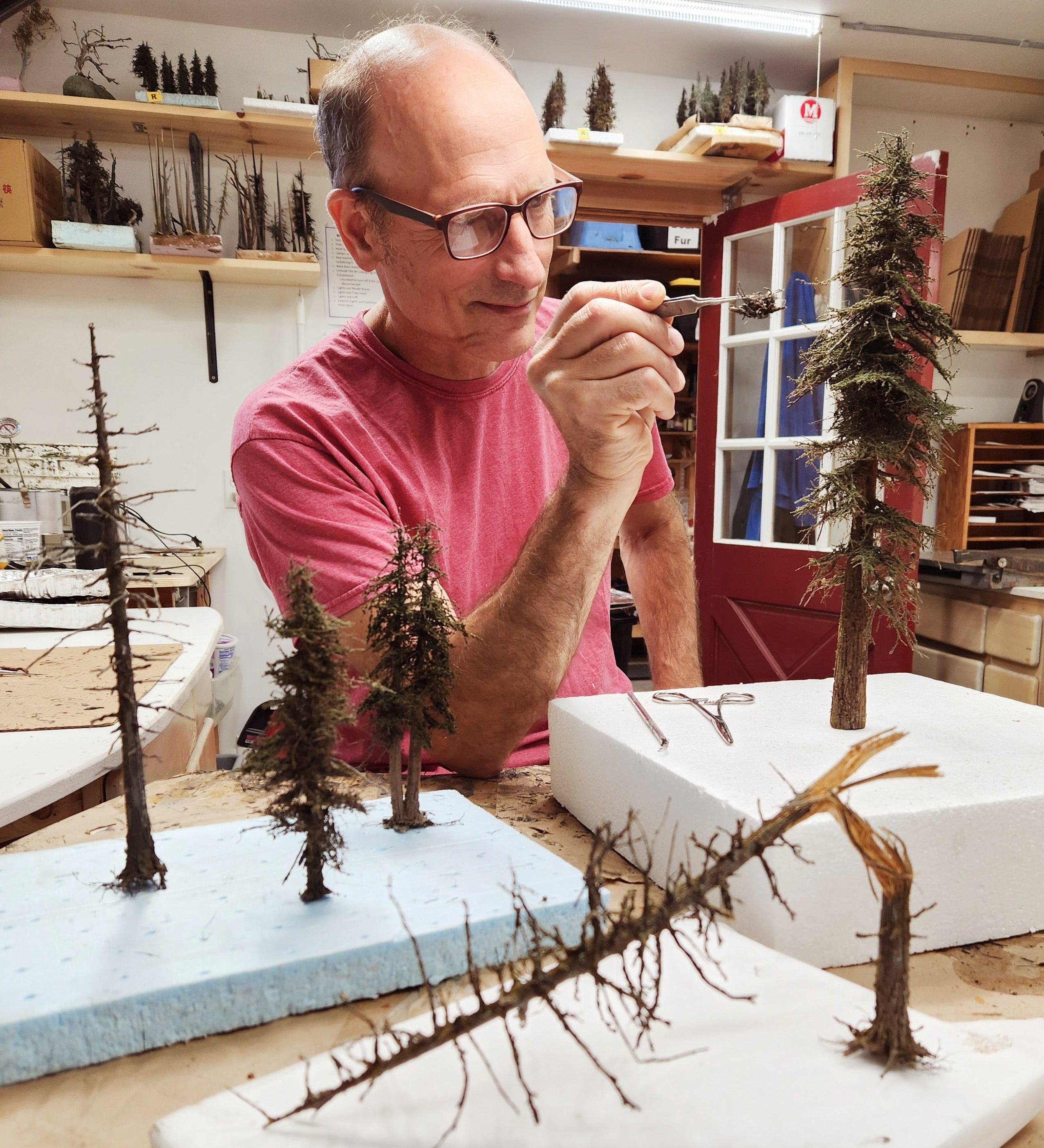 Man working on model trees in a workshop setting